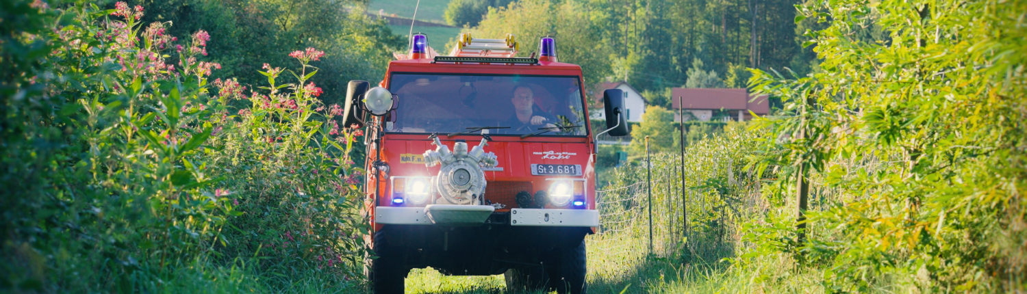Steyr-Puch-Pinzgauer als Feuerwehrauto fährt auf Wiesenweg