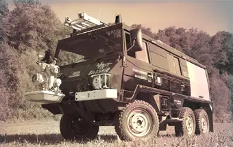 Titelbild: Steyr-Puch-Pinzgauer als Feuerwehrauto steht auf Wiese mit Wald im Hintergrund in Sepia-Farben
